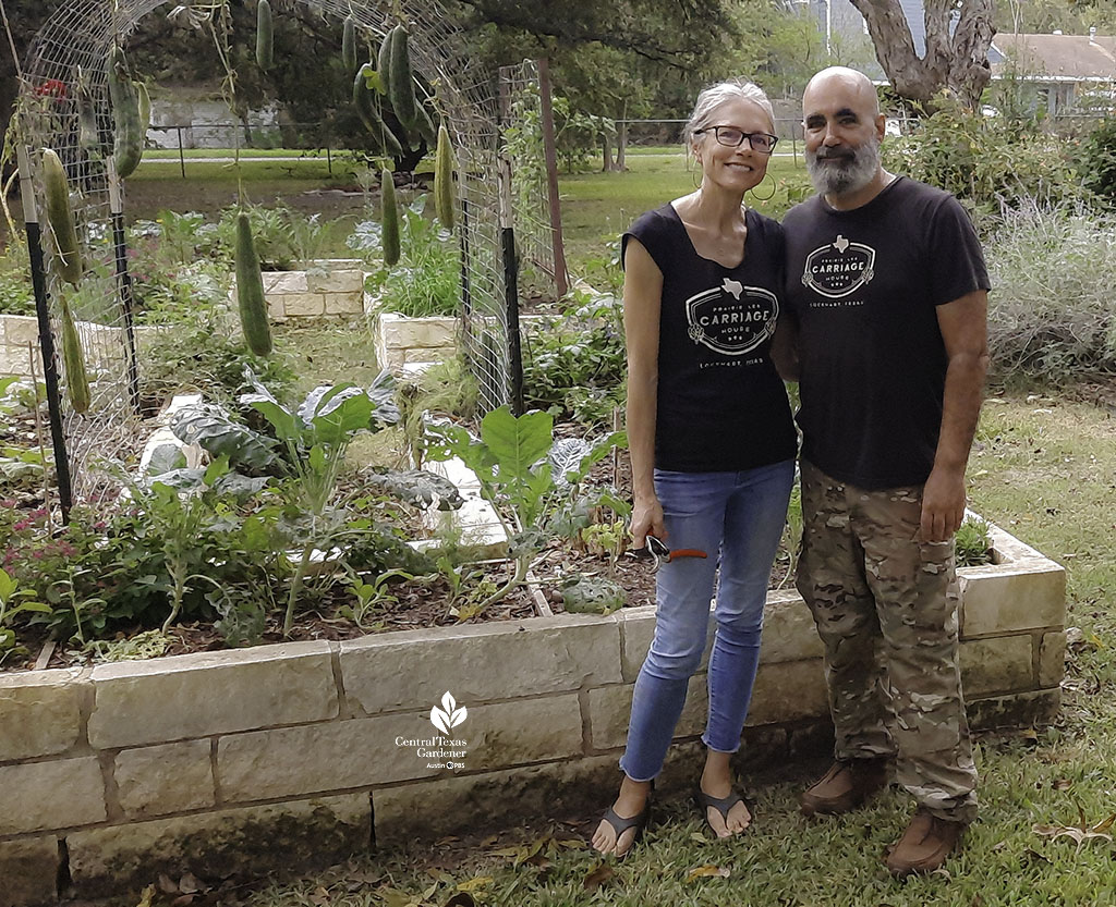 woman and man in front of raised limestone garden beds 