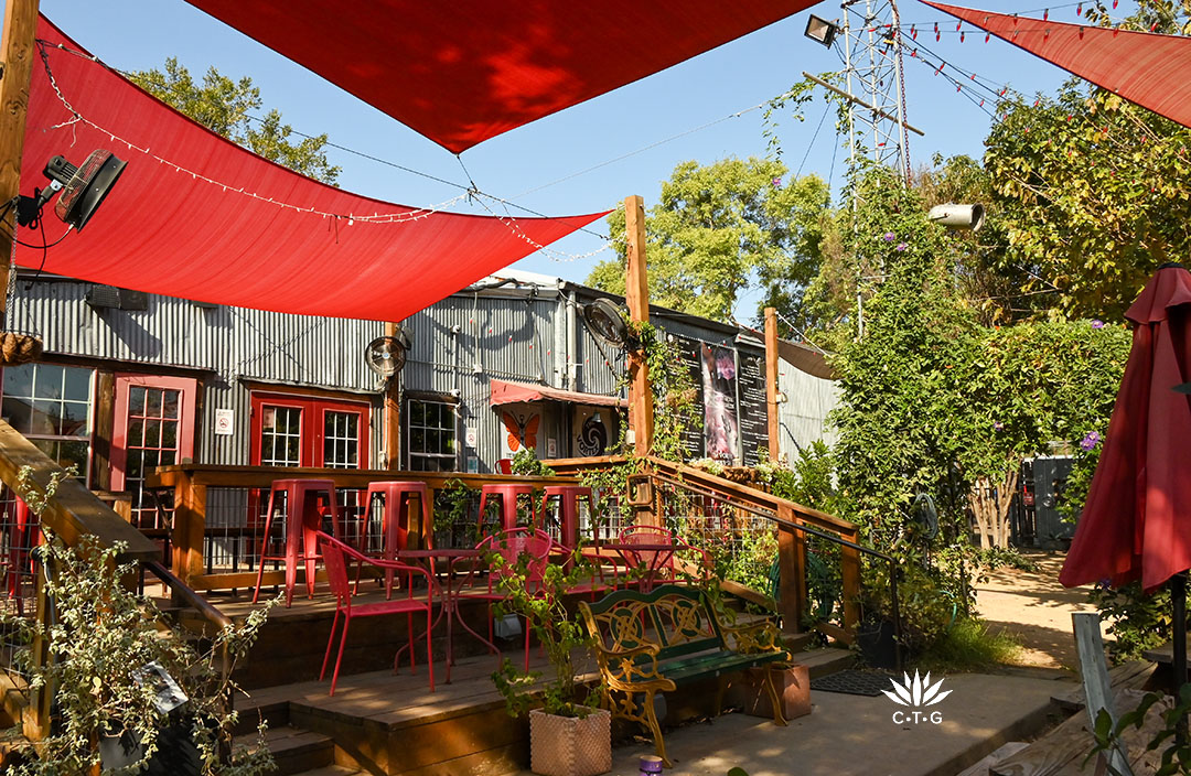 patio deck outside aluminum-sided building with plants framing it 