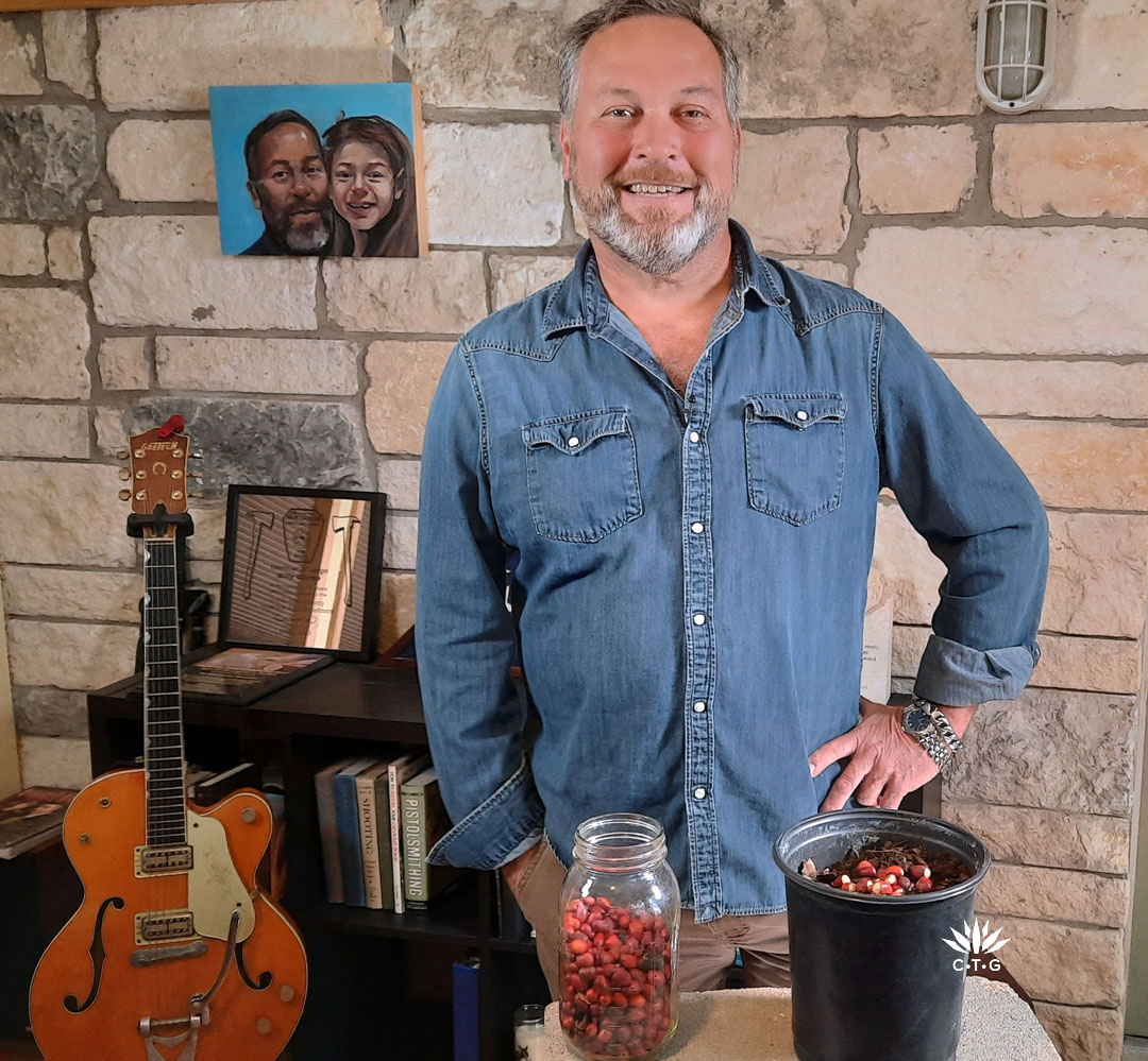 Billy Garza in stone-walled room with nursery pot of mountain laurel seeds and pruners