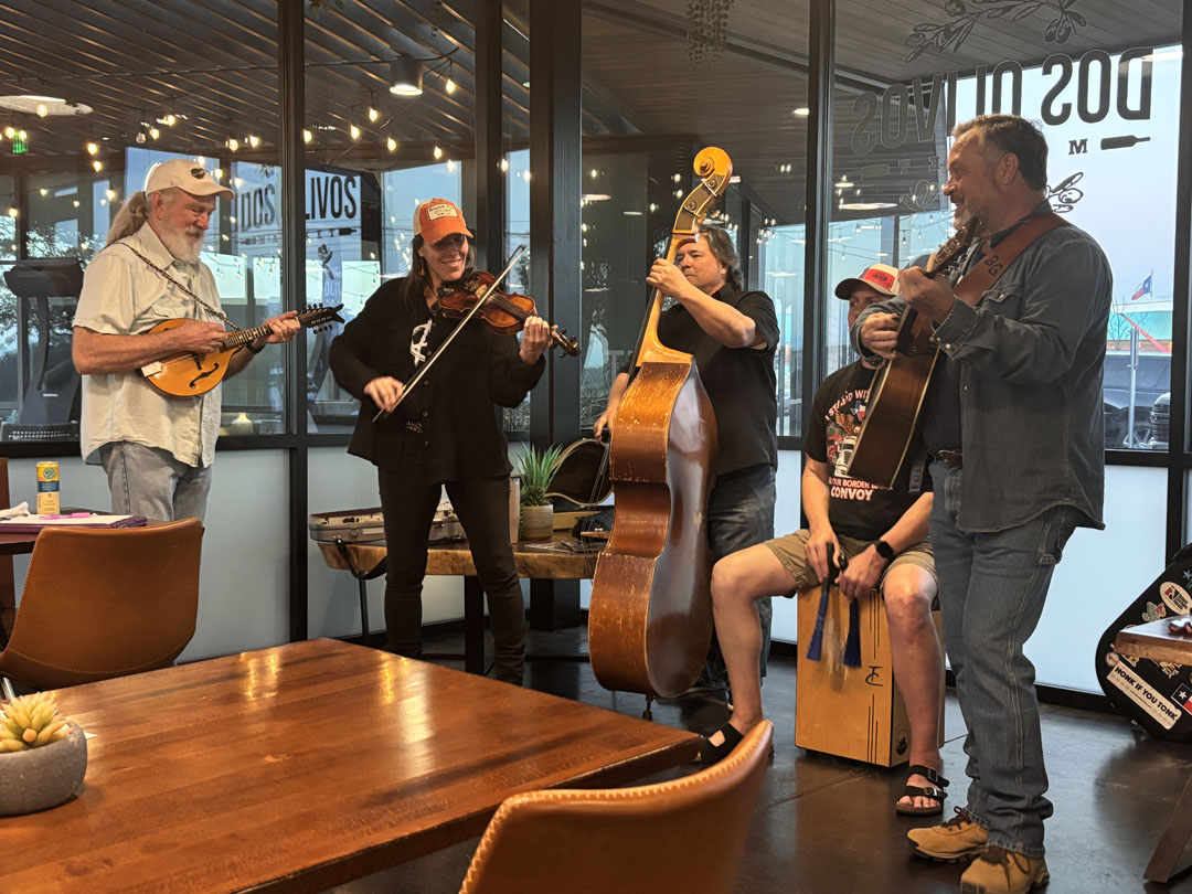 Billy Garza and three men and one woman playing instruments in restaurant 