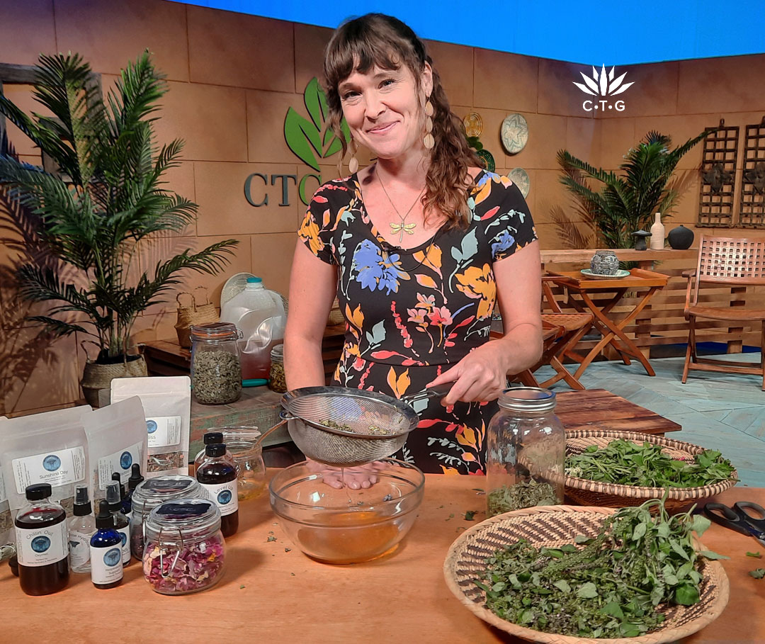 woman on CTG set with honey, baskets of herbs, and jars and bottles of herbs or tinctures