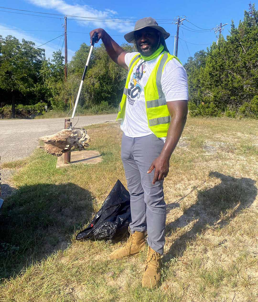 Black man holding up old animal skull on nature trail 