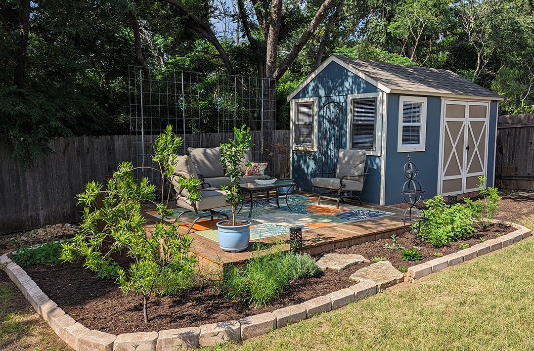 pretty blue shed with adjoined wooden deck dressed up with colorful rug and furniture
