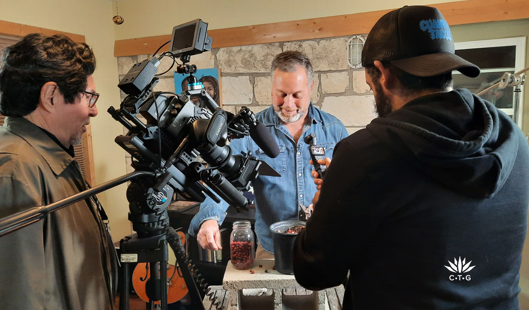 two men with camera taping Billy Garza clipping mountain laurel seeds