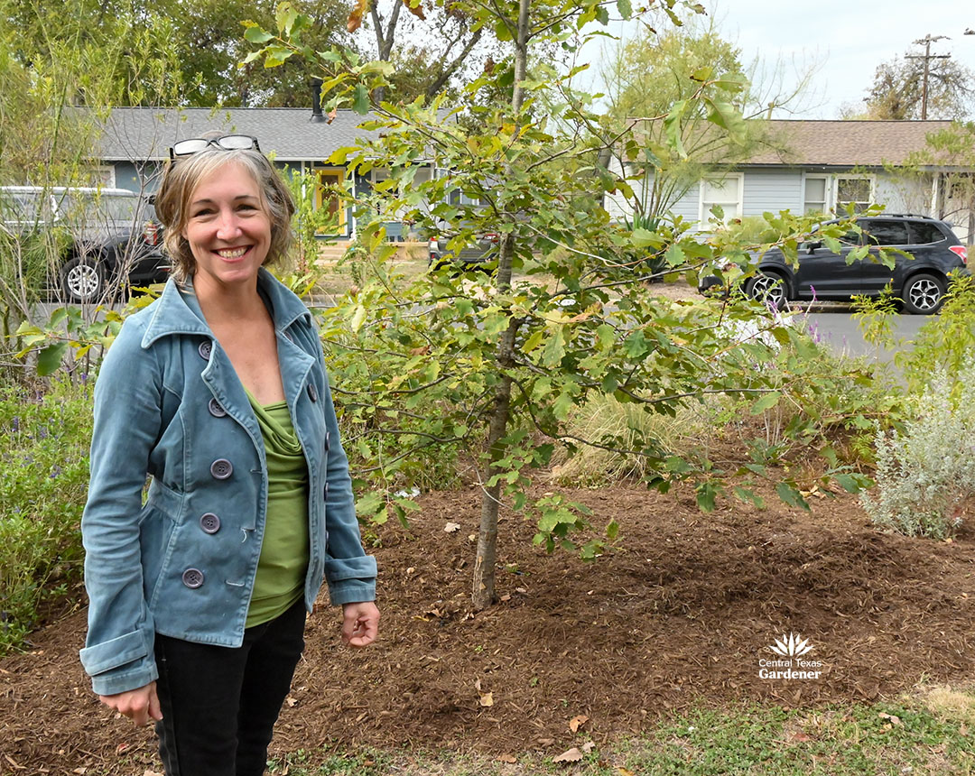 Paige in front yard garden next to a tree