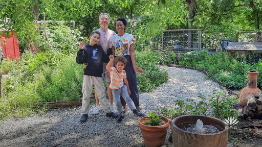 Richie and Nkiru Gelles with two young sons on garden path