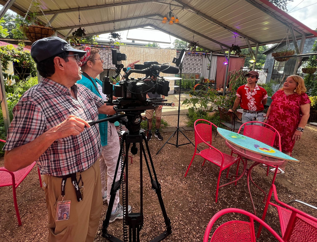 man behind video camera with woman next to him; interviewing Alex and Bonnie at Vortex gardens